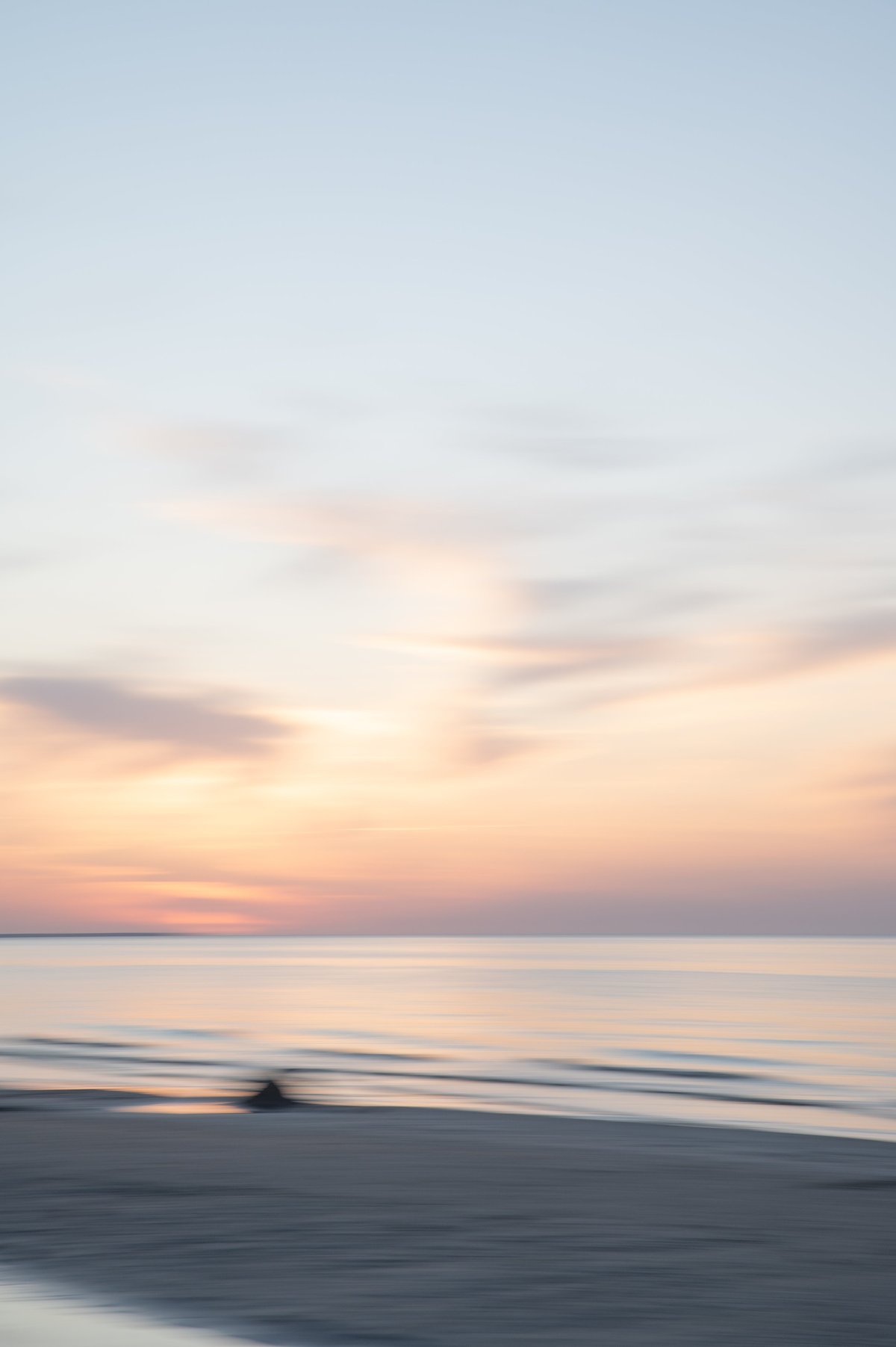 A tranquil seascape where the horizon gently blends the sky and sea. The atmosphere evokes peace, romance, and quiet reflection